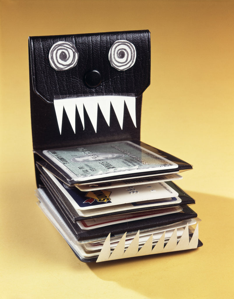 Detail of 1960s Symbolic Monster Wallet With Wild Eyes And Sharp Teeth Filled With Credit Cards by Corbis