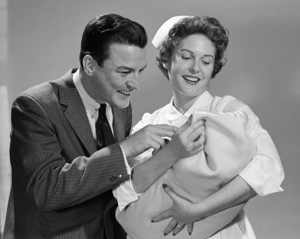 Detail of 1950s 1960s Man New Father Looking At Baby Held By Woman Nurse by Anonymous