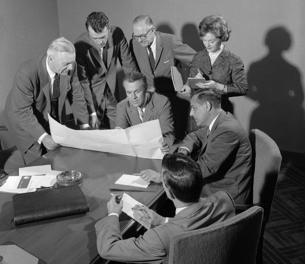 Detail of 1950s 1960s Conference Room With Men Looking Over Papers While Secretary Takes Notes by Corbis