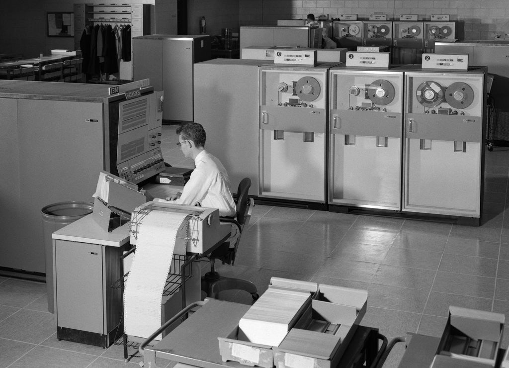 Detail of 1960s Man Programming Large Mainframe Computer Surrounded By Data Tape Drives Indoor by Corbis