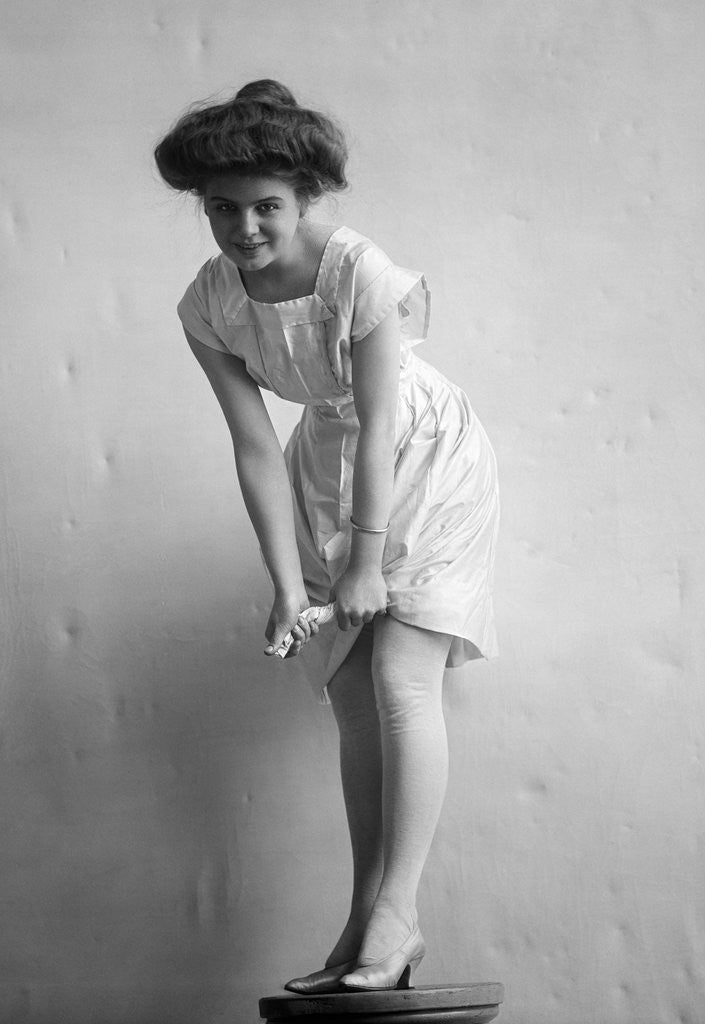 Detail of 1900s 1910s Woman With Gibson Girl Hair Style Ringing Out Wet Chemise Hemline by Anonymous
