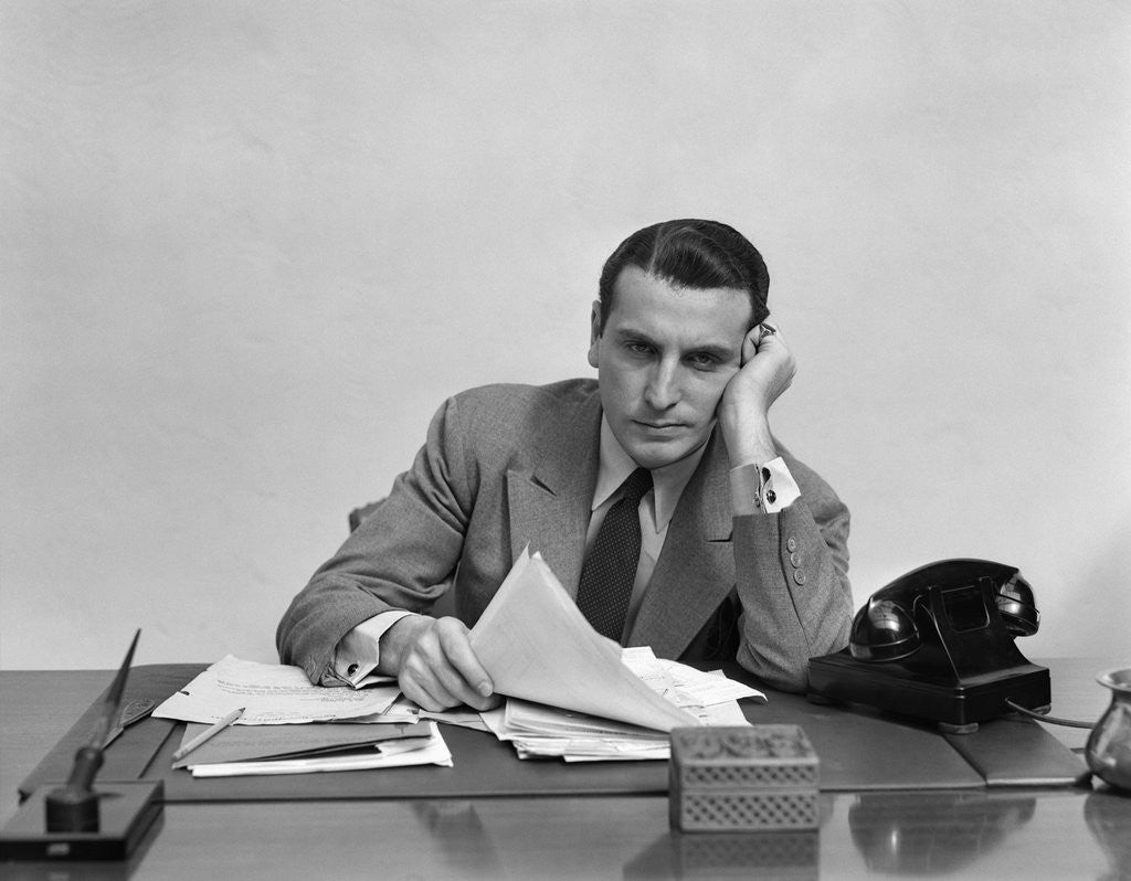 Detail of 1940s Tired Overworked Man Businessman Leaning On Elbow Looking At Camera by Corbis