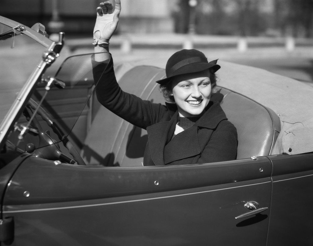 Detail of 1930s Woman Driving Convertible Roadster Automobile Waving Gloved Hand by Anonymous
