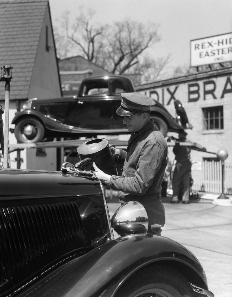 Detail of 1930s Service Station Attendant In Cap and Coveralls Pouring Water From Spouted Can Into Automobile Radiator by Anonymous