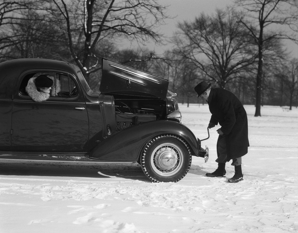 Detail of Woman Passenger Watching Man Motorist Try To Crank Start A Chevrolet Coupe Stalled In Snow by Anonymous