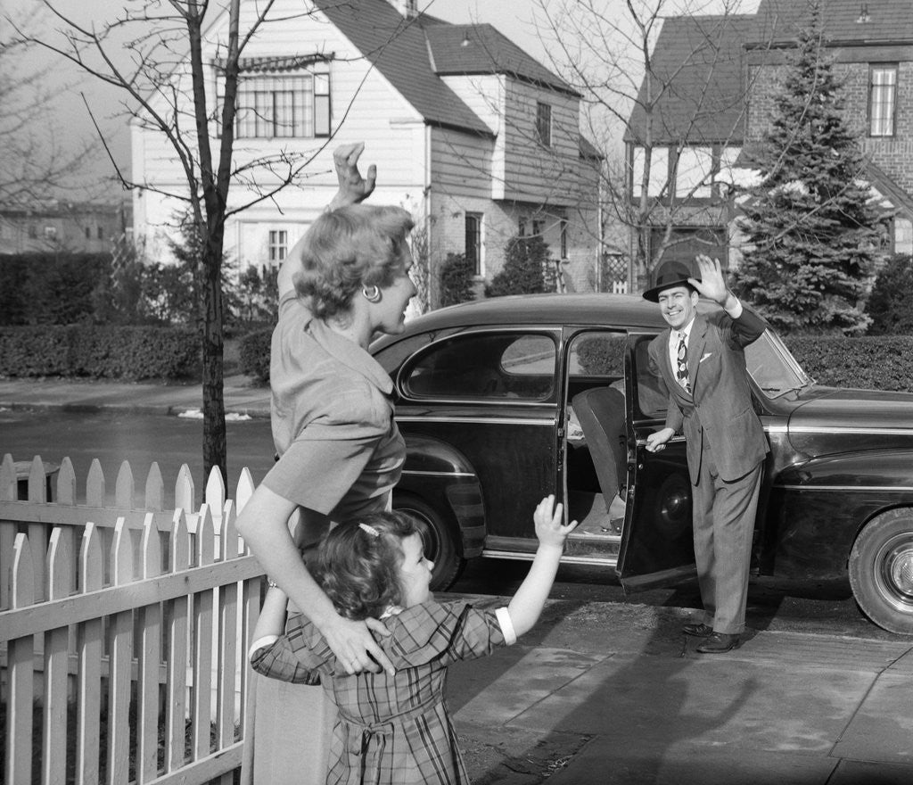 Detail of 1950s Mother And Daughter Waving To Father Opening Automobile Door In Front Of Suburban Home by Corbis