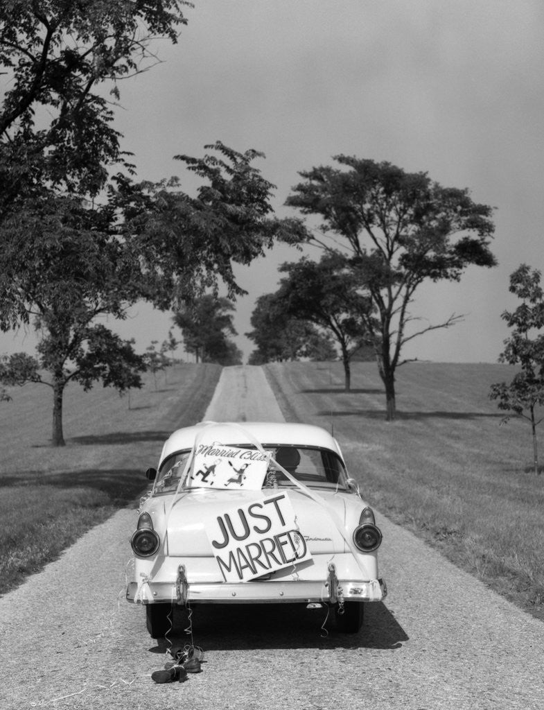 Detail of 1950s Back Of White Ford Sedan Driving Off With Just Married Sign by Corbis