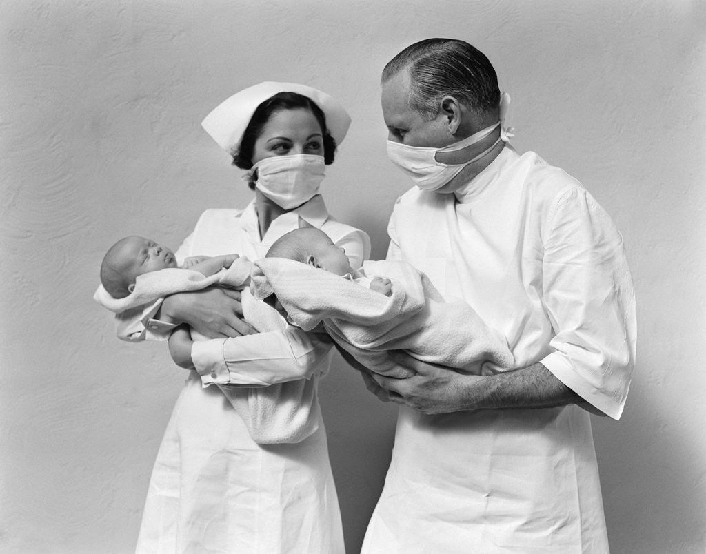Detail of 1930s 1940s Man Doctor Woman Nurse Wearing Sterile Masks Holding Newborn Infant Twin Babies by Anonymous
