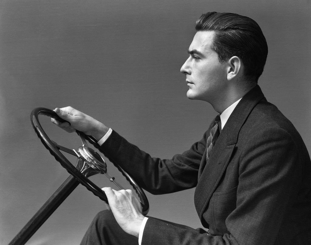 Detail of 1930s 1940s Man Wearing Suit And Tie Holding Automobile Steering Wheel by Anonymous
