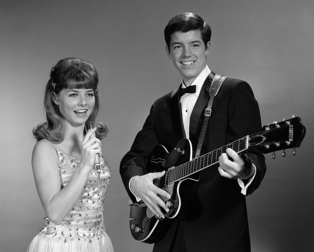 Detail of 1960s Teenage Entertainment Duo Man Playing Guitar And Woman Singing Holding Microphone by Corbis