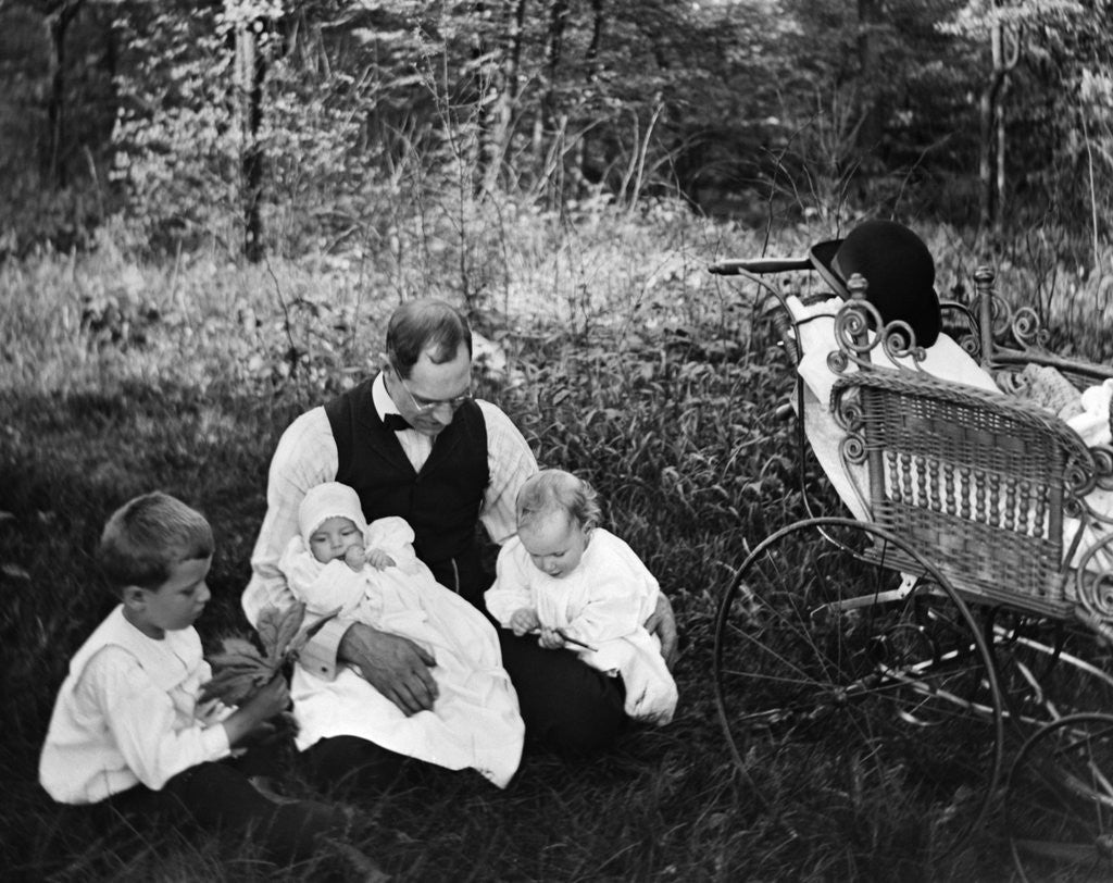 Detail of 1890s 1900s Father Sitting In Woods With Three Children Baby Carriage Off To Side by Corbis