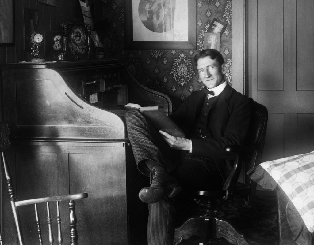 Detail of 1890s 1900s Man Sitting At Desk Reading Book by Corbis