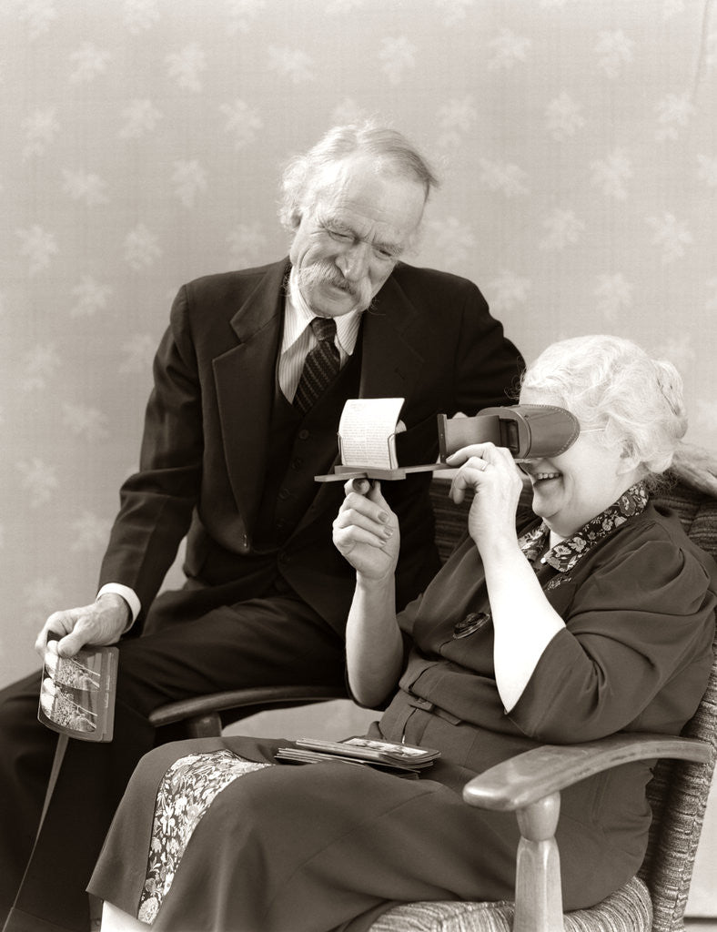 Detail of 1940s Older Senior Couple Man Woman Viewing Photographs By Stereopticon Stereoscope by Anonymous