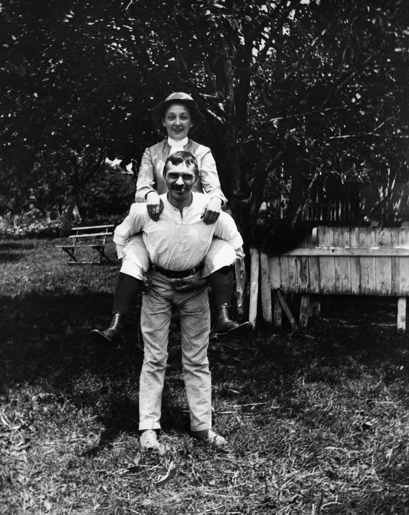 Detail of 1900 Man Smoking Cigar Carrying Wife Piggyback by Anonymous