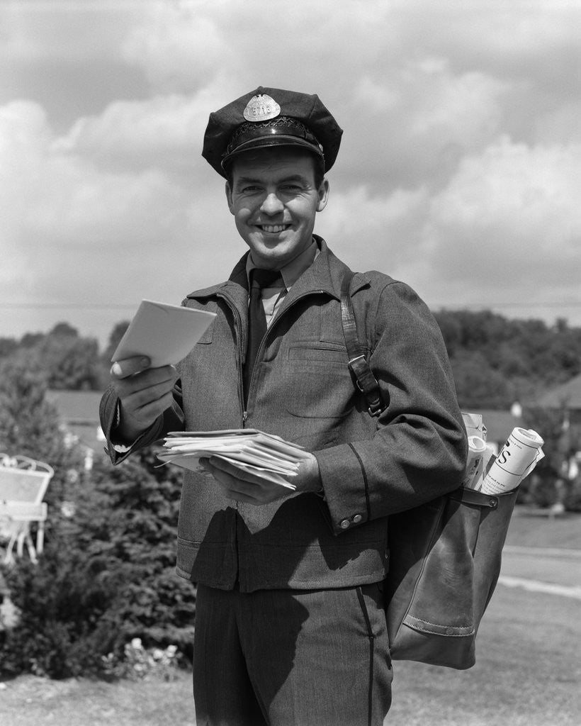 Detail of 1950s Man Postman Holding Out Letter by Corbis
