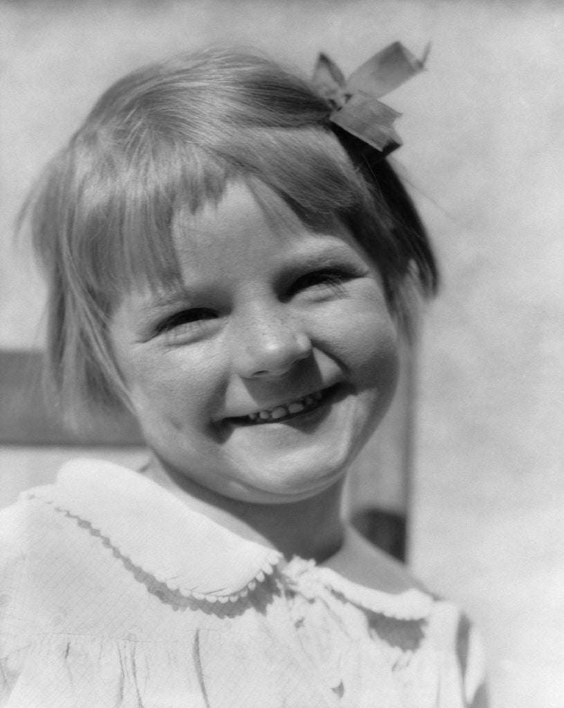 Detail of 1930s Young Girl Outdoor Portrait With Freckles And Bow In Hair At Camera by Anonymous