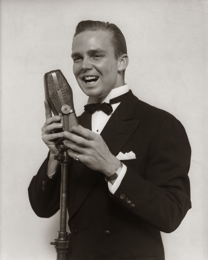 Detail of 1920s 1930s Man Radio Singer Entertainer Crooner In Tuxedo Singing Into Microphone by Corbis