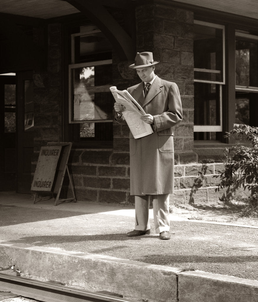 Detail of 1950s Businessman On Railroad Station Platform Reading Newspaper Waiting For Train by Anonymous