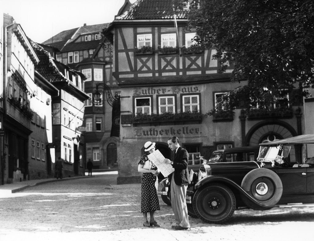 Detail of 1930s Tourist Couple By Car Looking At Map In Front Of Eisenach Lutherhaus 1563 Where Luther Lived While Attending School by Corbis