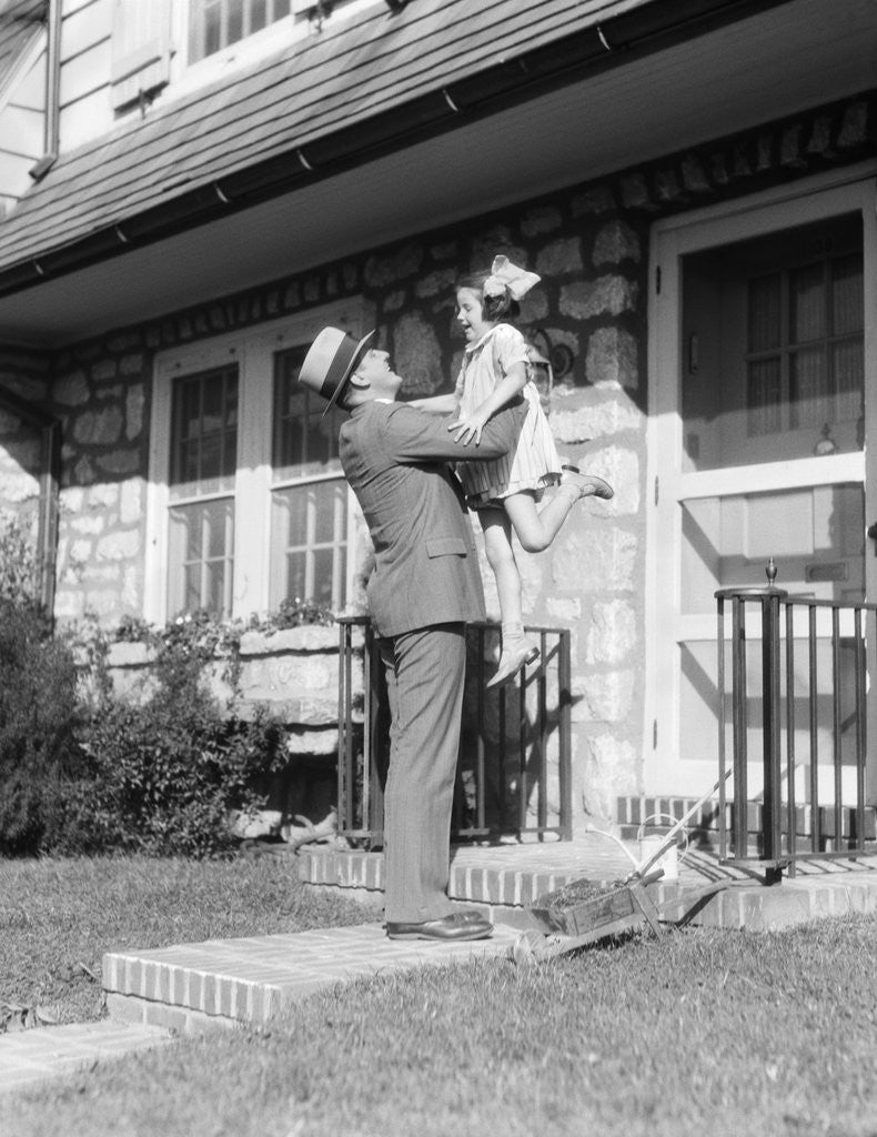 Detail of 1930s Returning Father Lifting Up Laughing Daughter In Front Of Stone Suburban House by Anonymous