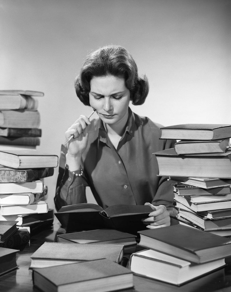 Detail of 1950s 1960s College Woman Studying Surrounded All Around By Piles Of Books by Anonymous