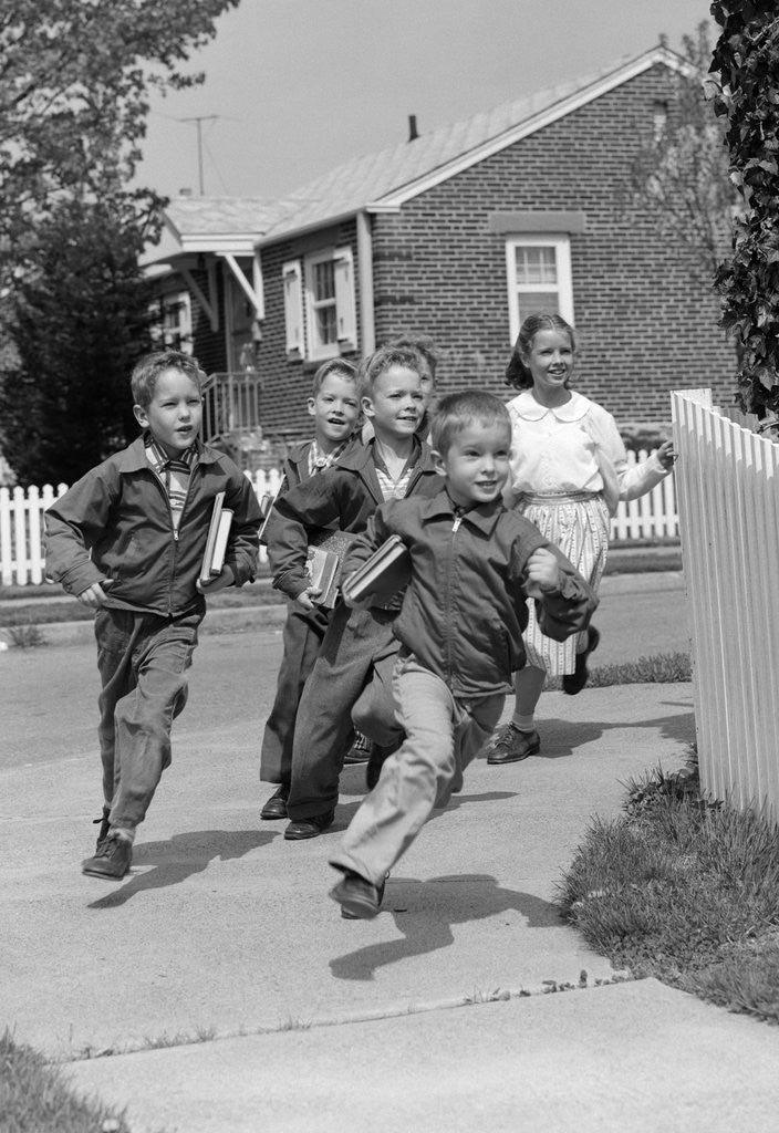 Detail of 1950s School Children Running Around Corner Of Picket Fence In Suburban Neighborhood by Corbis