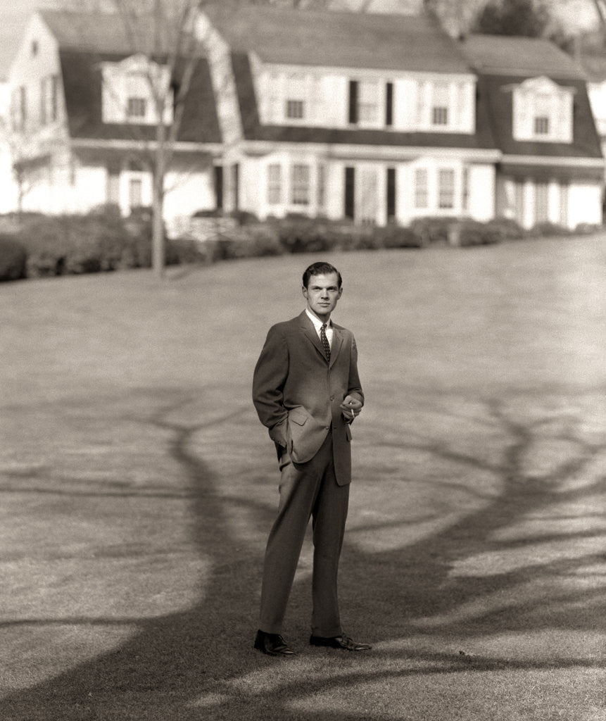 Detail of 1950s Executive In Gray Flannel Suit And Tie Standing On Suburban Home Lawn by Corbis