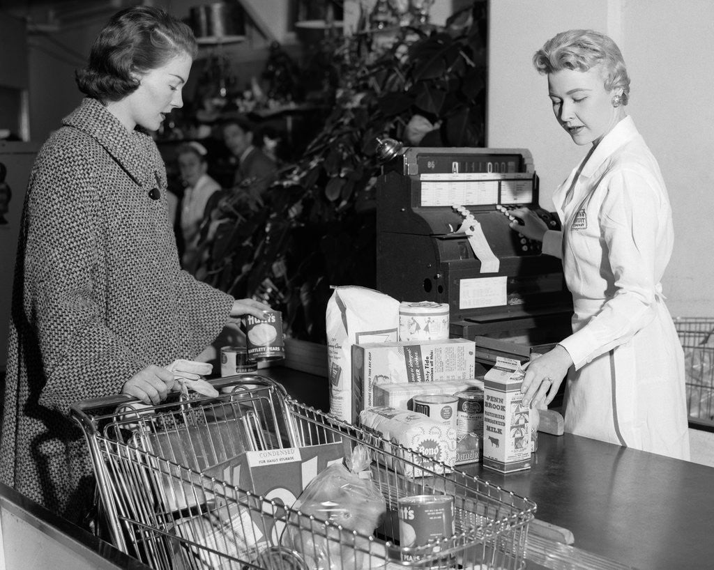 Detail of 1950s Woman At Grocery Store Checkout Counter Handing Items Over to Cashier by Corbis