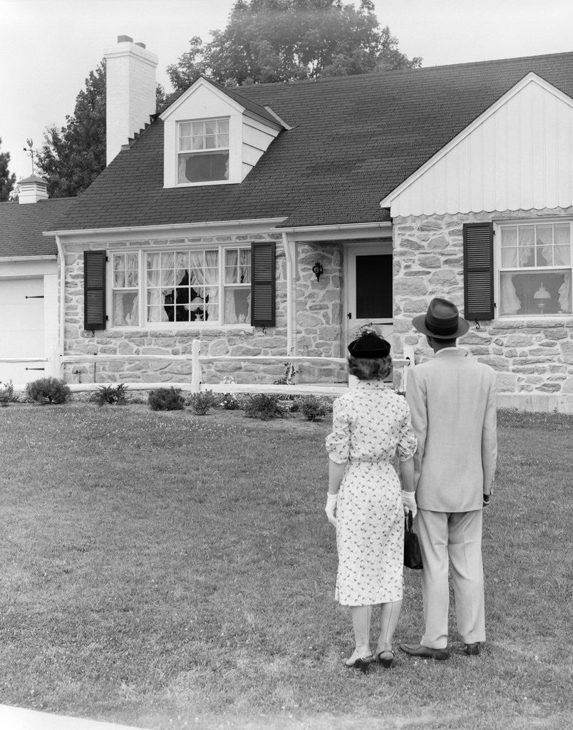 Detail of 1940s 1950s Couple Standing Outside Looking At Stone Suburban House by Anonymous