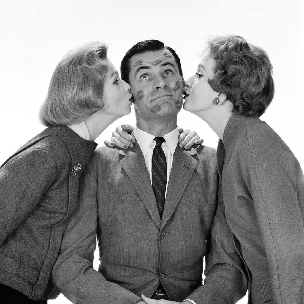Detail of 1950s Two Women Kissing Single Man On Opposite Cheeks His Face Covered With Lipstick Marks by Corbis