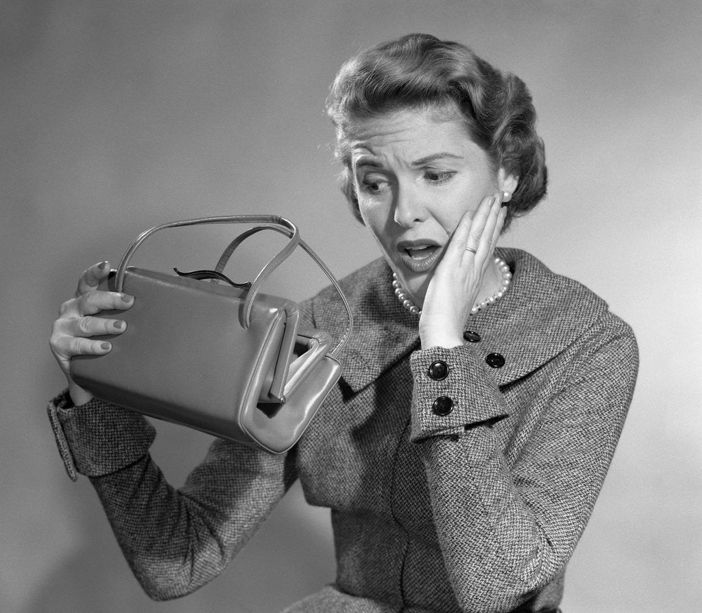 Detail of 1950s Woman With Exaggerated Expression Hand On Face Looking Inside Her Purse by Corbis