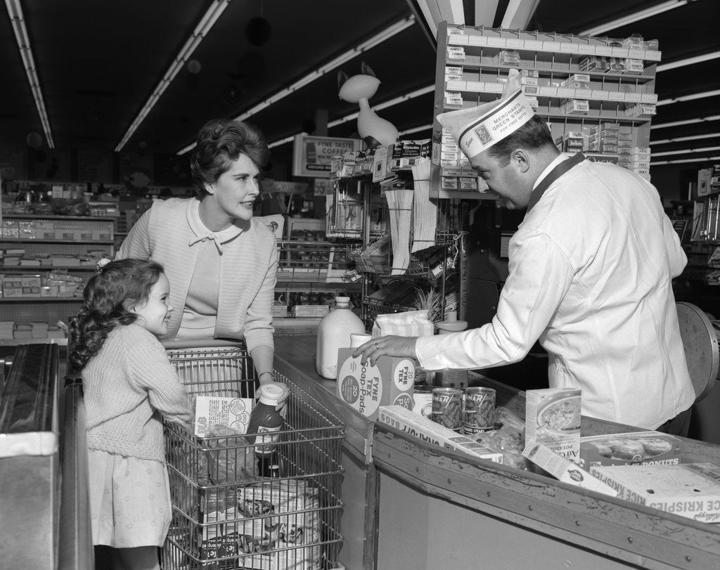 Detail of 1960s Mother Daughter Unload Grocery Cart At Supermarket Checkout Counter by Anonymous