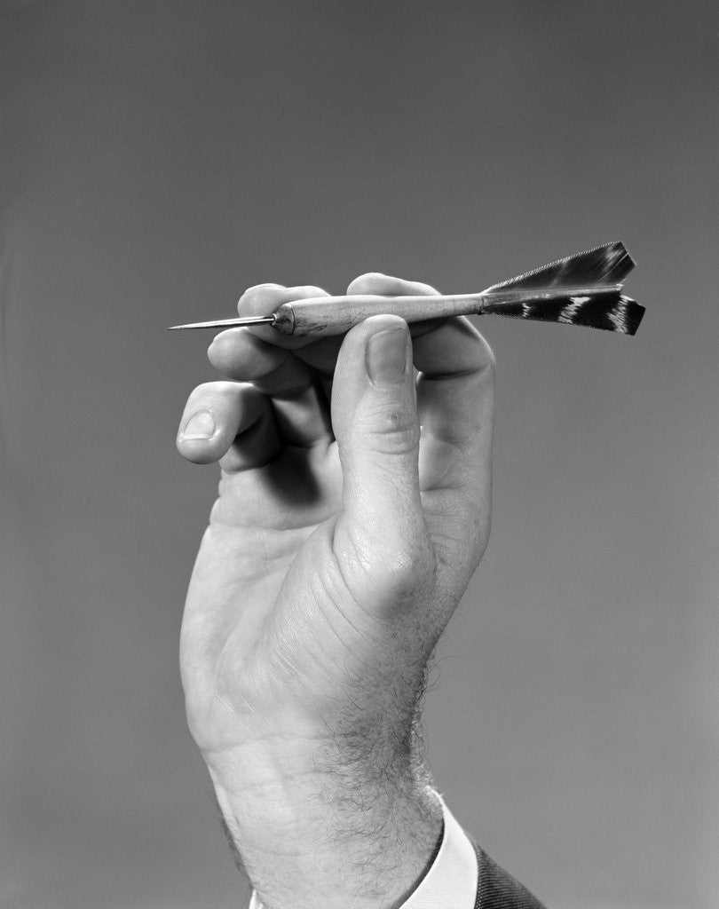 Detail of 1960s 1970s Hand Close-Up Holding About To Throw A Sharp Pointed Dart by Anonymous