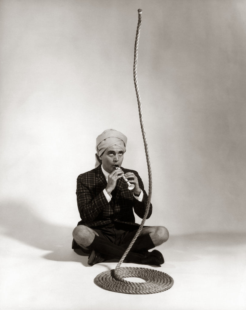 Detail of 1960s Man Snake Charmer Character In Turban Plaid Jacket Shorts Knee Socks by Anonymous