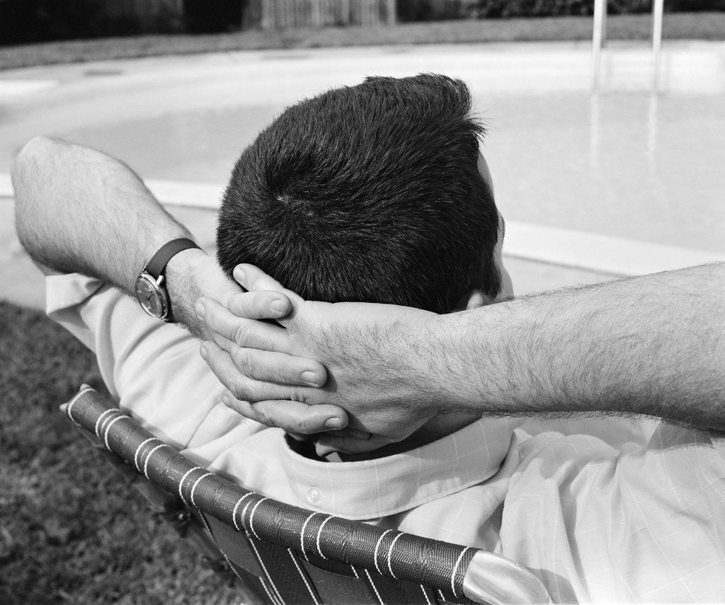 Detail of 1970s Man With Hands Folded Behind Head Stretched Out In Lounge Chair Poolside by Anonymous