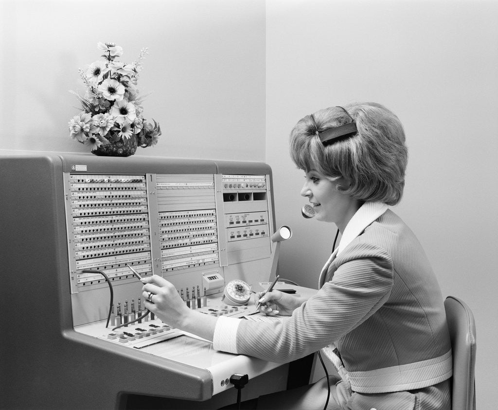 Detail of 1970s Receptionist Working Answering Office Telephone Switchboard Wearing Headset by Corbis