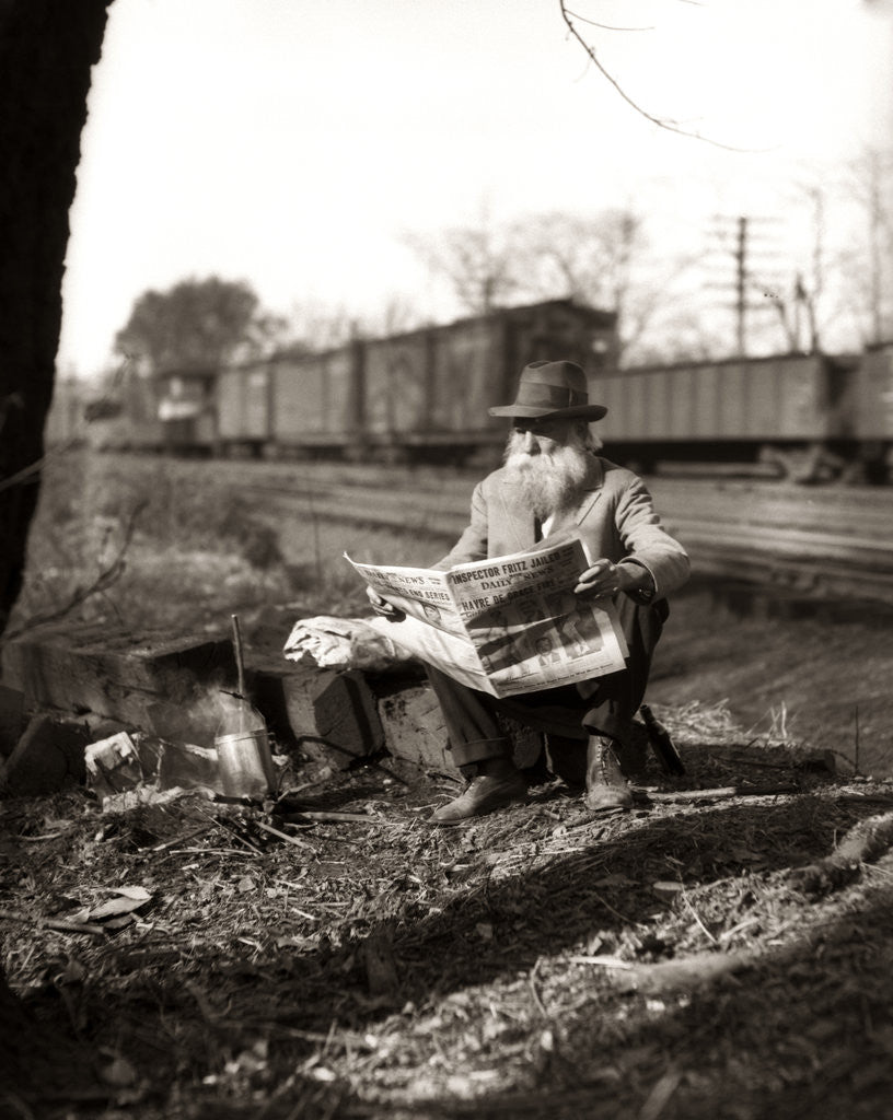 Detail of 1930s Hobo Sitting By Railroad Track Reading Newspaper During Great Depression by Corbis
