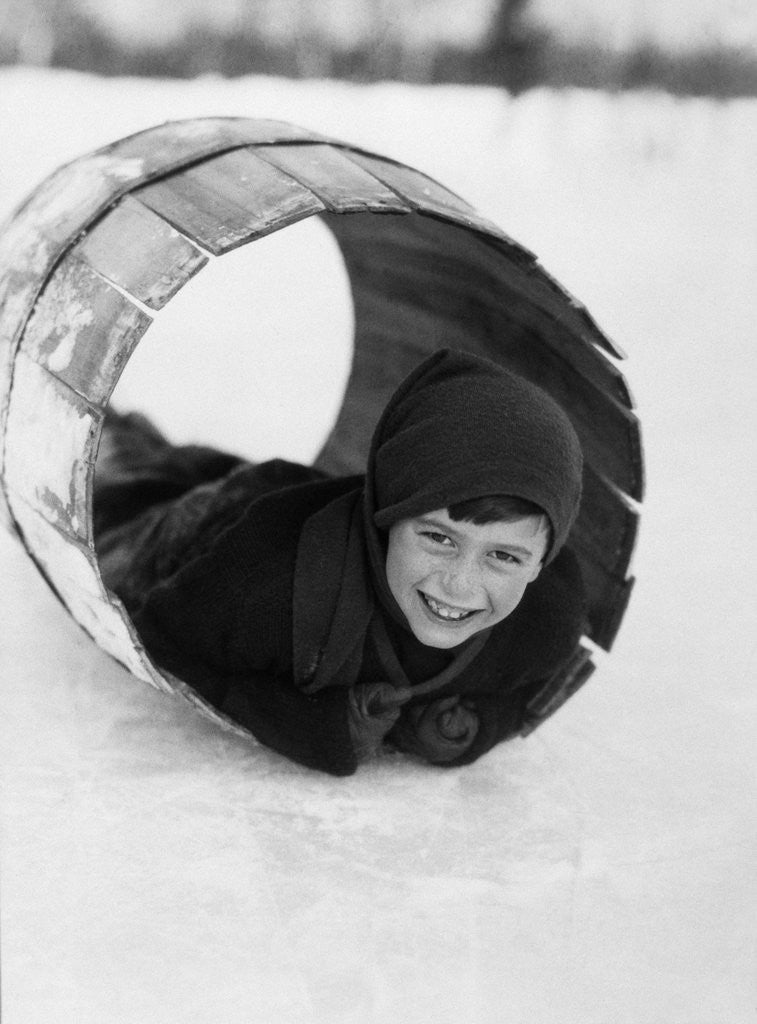 Detail of 1920s Boy Playing Lying In Snow Rolling In Wooden Barrel by Anonymous