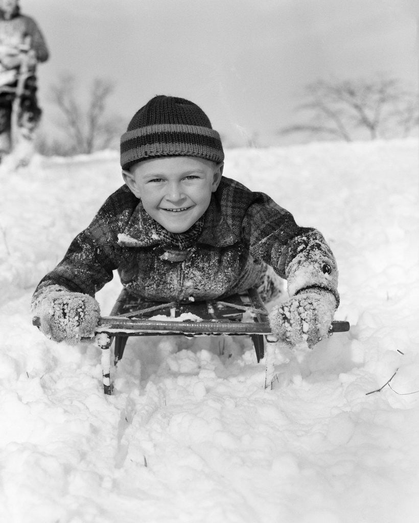 Detail of 1940s Boy On Sled In Snow Facing Camera Hands And Jacket Covered In Snow by Anonymous