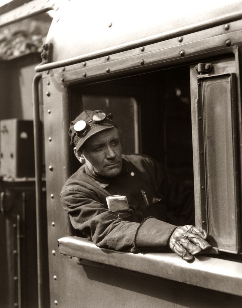 Detail of 1920s 1930s 1940s Railroad Train Engineer Looking Out Window Of Locomotive Cab Driving The Steam Engine by Anonymous