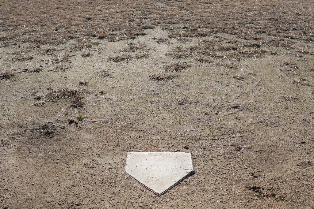 Detail of Home Plate on Field of Dirt and Dead Grass by Anonymous