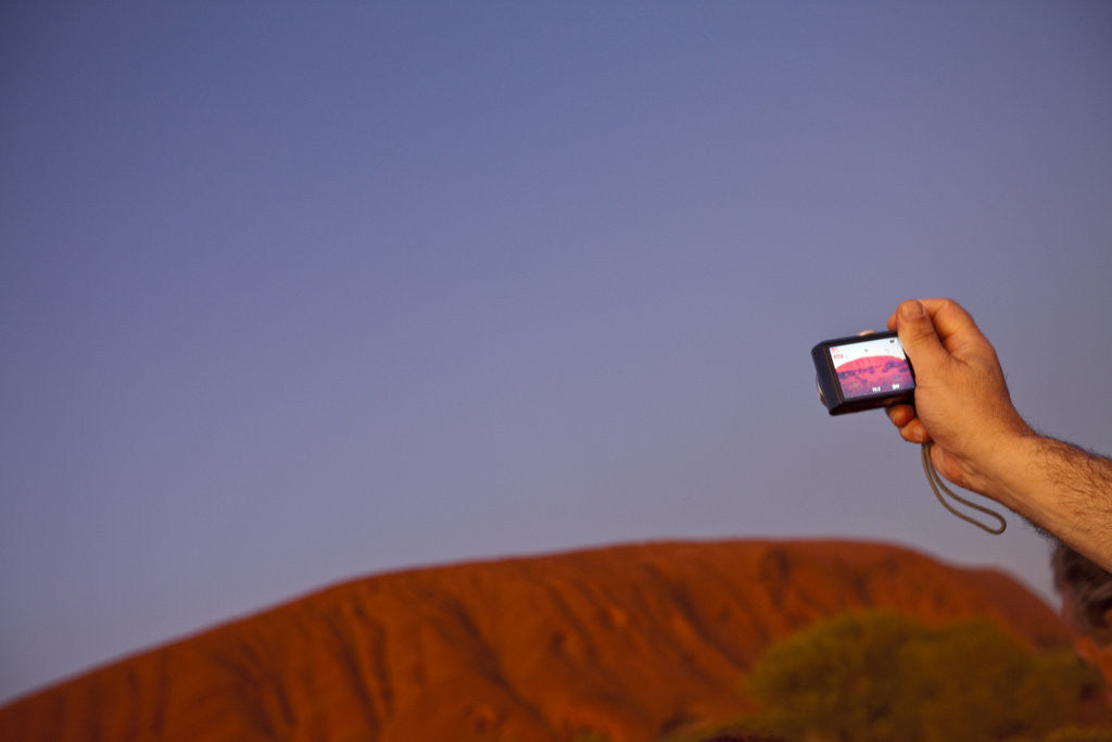 Tourist photographing Ayers Rock in the Australian Outback by Corbis