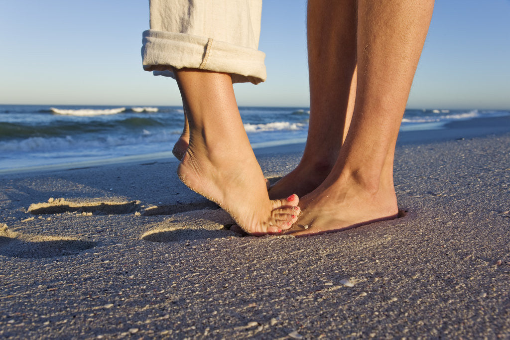 Detail of Feet of couple hugging on beach by Anonymous