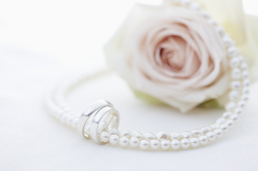 Detail of Necklace, wedding rings and flower by Anonymous