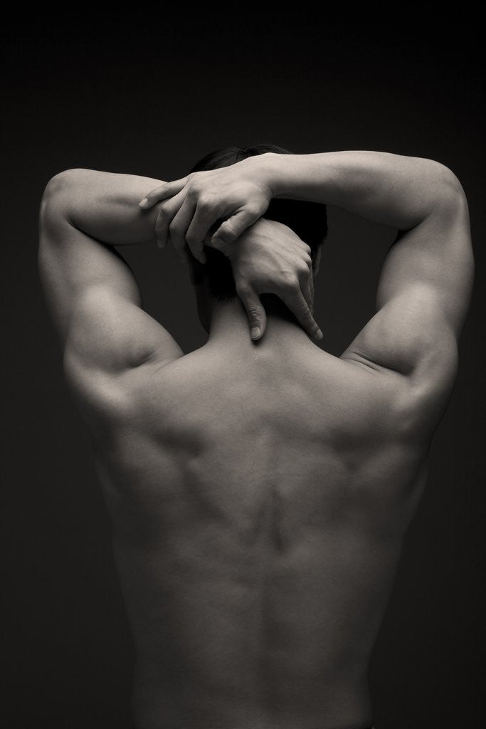 Detail of Rear view of a male stretching his arm behind his head by Corbis