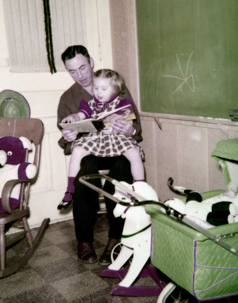 Detail of A father reads to his 4 year old daughter, ca. 1957 by Anonymous