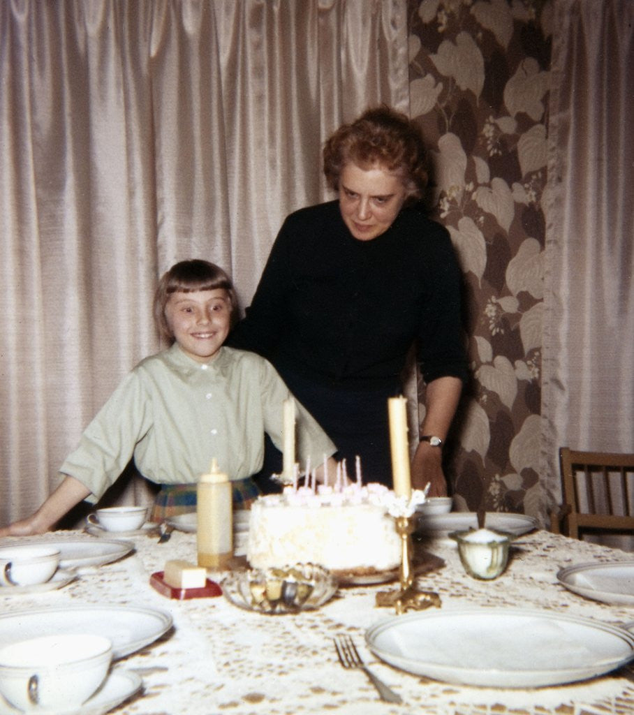 Detail of Nine year old girl is about to blow out the candles on her while her mom watches, ca. 1962 by Anonymous