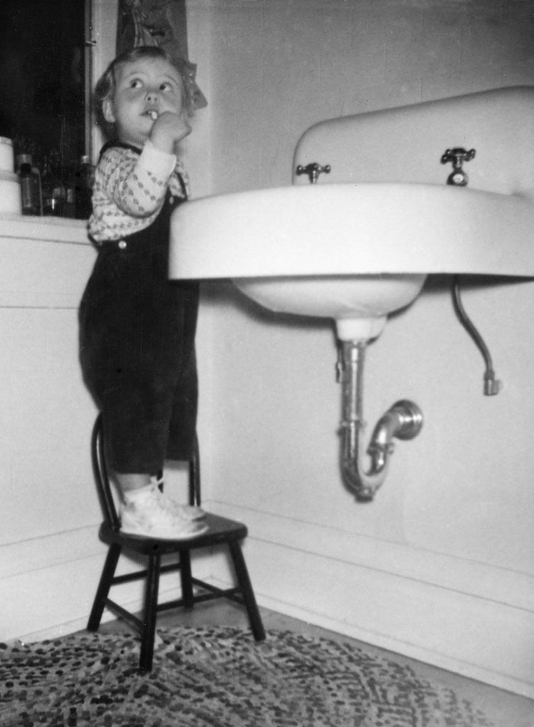 Detail of A young girl brushes her teeth at the sink, ca. 1955 by Anonymous