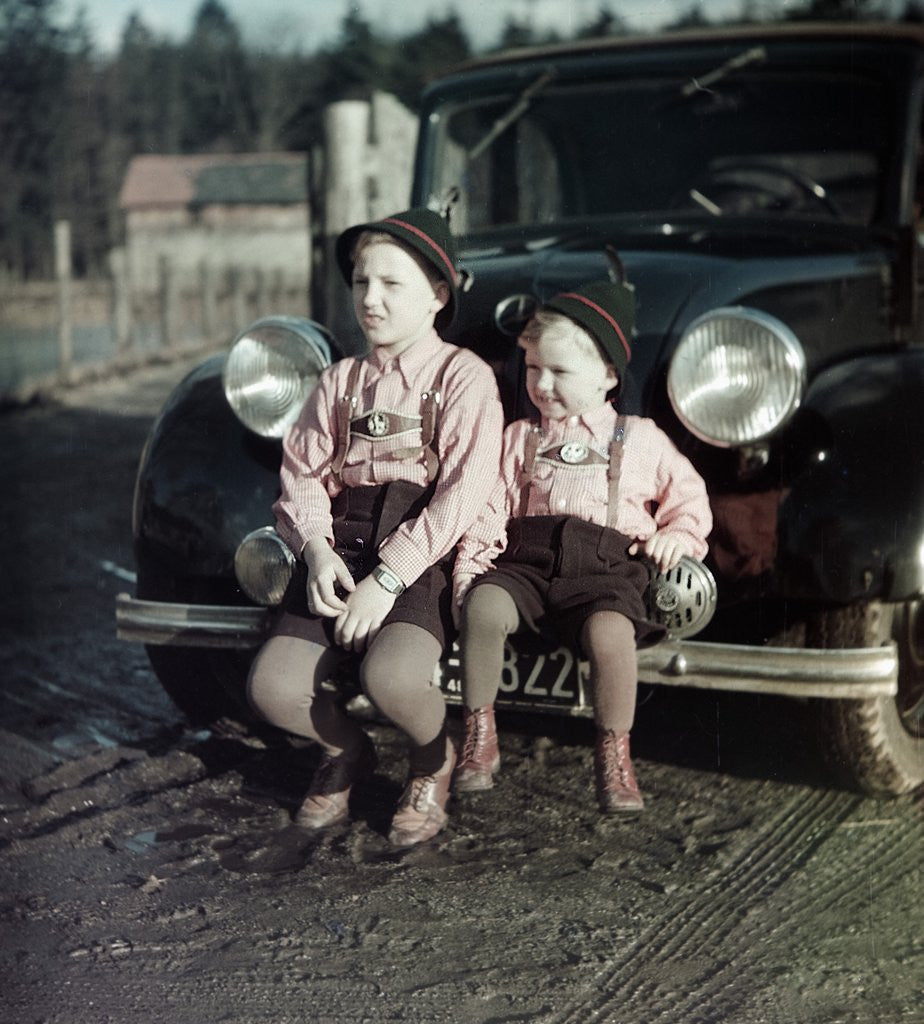 Detail of Two brothers sit on the bumper of the family Mercedes Benz in Germany, ca. 1949 by Corbis
