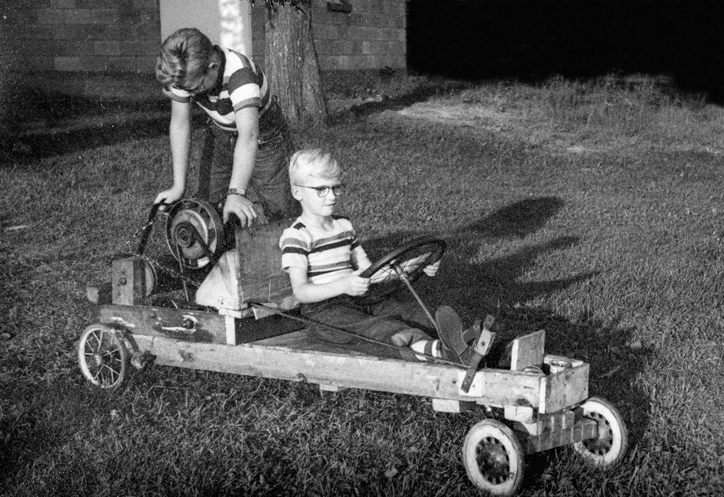 Brothers play with their homemade go cart, ca. 1955 by Corbis